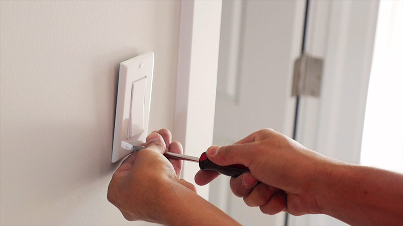 Worker installing wireless light switch - electrician-construction-labor-shortage